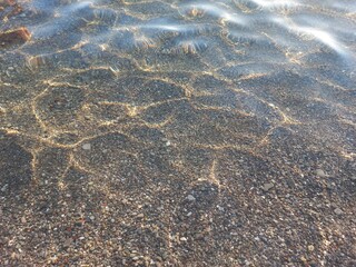 Clear waters revealing pebbles beneath the surface in Montenegro's tranquil beach setting
