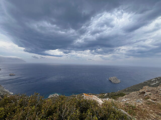 Storm front over Amorgos – dramatic seascape with isolated rock islet and turbulent skies