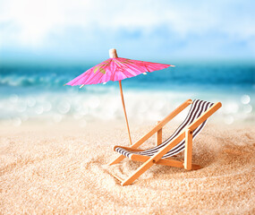 Beach chairs on the gold sand beach with umbrella, cloudy blue sky and sun