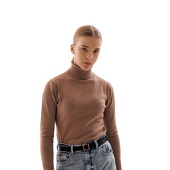 Young woman poses confidently in casual sweater and jeans against a plain white background