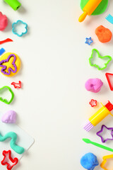 Colorful play dough and various shaped cutters on a white background