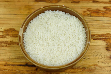 A brown ceramic bowl filled with white rice.
