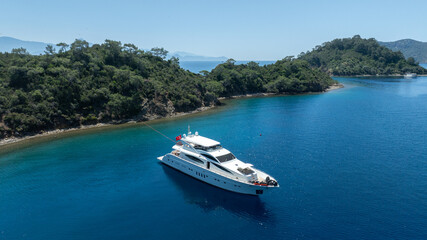 Fototapeta premium Luxurious White Yacht Anchored in a Tranquil Bay 
