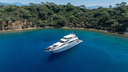 Obraz premium Luxurious White Yacht Anchored in a Tranquil Bay 