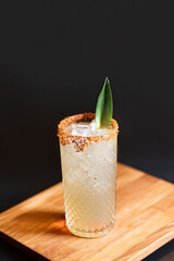 Tropical Cocktail in Tall Glass with Pineapple Leaf and Chili Rim