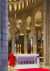 Principality of Monaco, France - July 9, 2024: Cathedral of Our Immaculate Lady. Main altar with candles, red carpet, and columned background