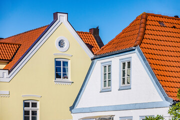 Two colorful houses with clay tile roofs showing traditional nordic european architecture