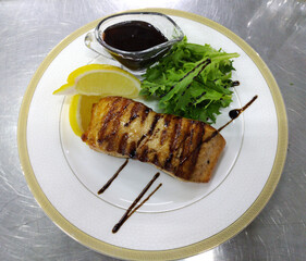 Grilled sturgeon steak with a slice of lemon, cherry tomatoes and fresh herbs. proper and healthy nutrition. diet and healthy lifestyle