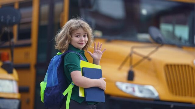 School kid waving hand near school bus. Child go to school bus. American education scene. School moment. USA childhood memory. Learning today. Child with sook and backpack ready to lesson.