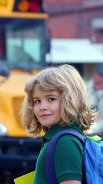 School kid waving hand near school bus. Child go to school bus. American education scene. School moment. USA childhood memory. Learning today. Child with sook and backpack ready to study.
