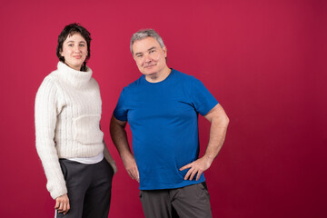 Father and daughter smiling together on red background