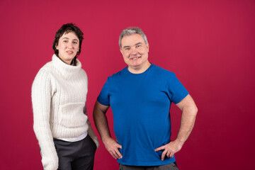 Confident man and woman smiling on red background