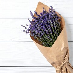 Rustic lavender bouquet wrapped in brown kraft paper on white wooden background