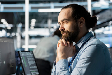 Computer scientist in data center doing software updates, verifying neural network metrics. Server...