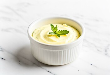 A white bowl filled with butter and a sprig of rosemary.