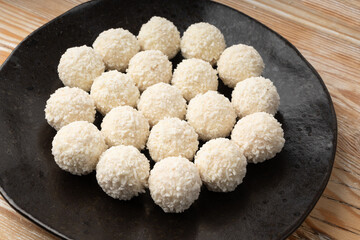 Coconut candies pile, coco ball. White truffle ball, indian ladoo or laddu with sweet cream and coco