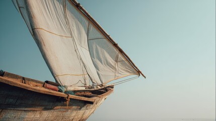 Fototapeta premium Minimalist white sailboat with large sail peacefully gliding on calm blue ocean waters