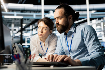 Data center coworkers doing brainstorming, running diagnostic scripts on computer, examining...