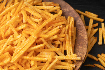 Fried chips sticks, finger potato chips, golden shoestring fries pile, French fries