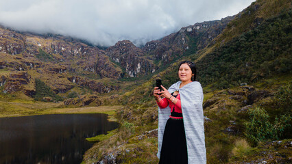 Mujer quechua en vestimenta tradicional en América Latina, feliz mientras usa un teléfono...