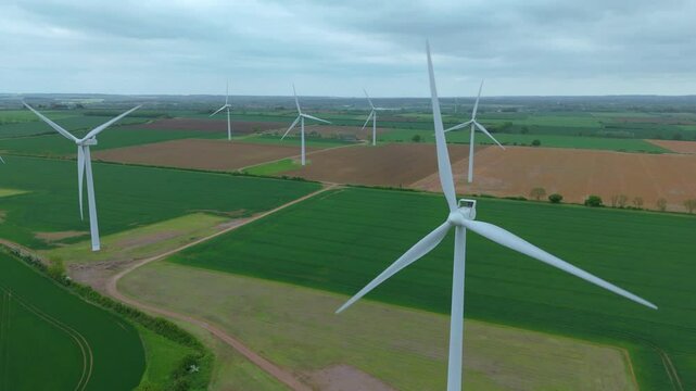 Aerial drone view renewables wind turbines energy electricity gas coal fossil fuels green rural fields generation England UK Biggleswade 
