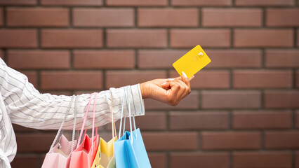 Discount for shop and payment for purchase. African american woman with multicolored packages gives...