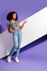 Stylish young woman smiling and gesturing on a purple vertical background, expressing happiness and...