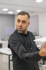 Fototapeta premium Caucasian bearded man launching paper airplane in office. 