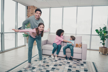 Smiling family enjoying playful moments together indoors in a bright living space showcasing...