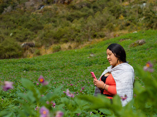 Campesina Quechua en Chacra con Celular., feliz mientras usa un teléfono inteligente mirada a un...