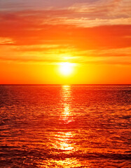 Hermoso atardecer con sol brillante y reflejado en el mar.