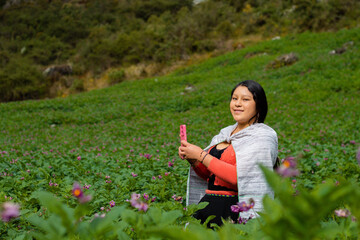 Campesina Quechua en Chacra con Celular., feliz mientras usa un teléfono inteligente mirada a un...