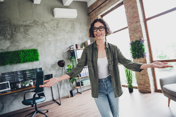 Young programmer standing confidently in stylish office interior with modern decor and vibrant...