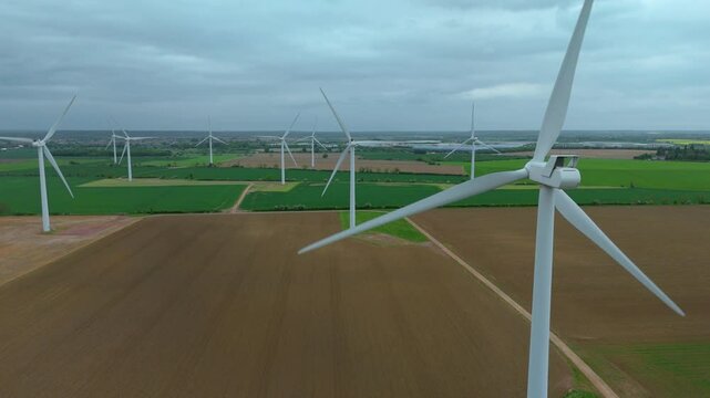 Aerial drone view renewables wind turbines energy electricity gas coal fossil fuels green rural fields generation England UK Biggleswade 