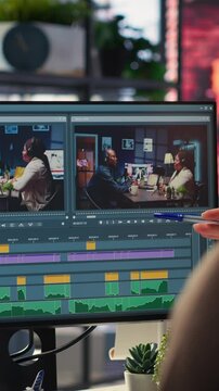 Vertical Video Video editors team working with AI chatbot and montage maker software, editing a background video and mixing clips on dual monitors. Professional man and woman in creative process