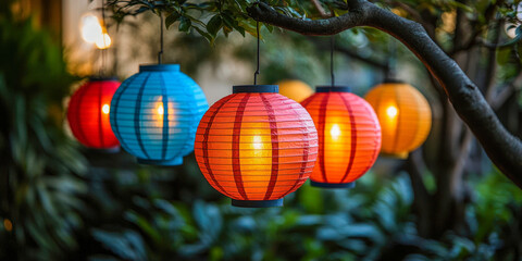 Vibrant paper lantern decorations illuminate a backyard BBQ cookout party in the evening