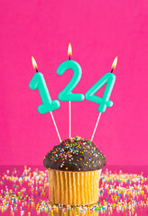 Birthday cupcake with number 124 candle - Celebration card on fuchsia background