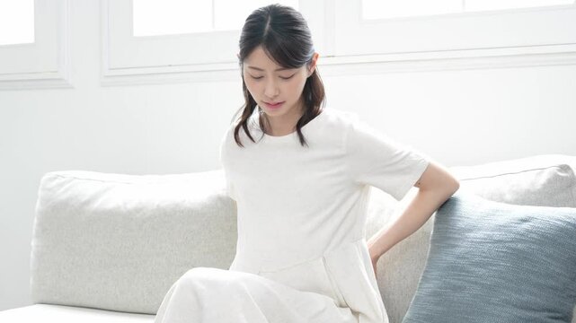 腰をおさえる妊婦