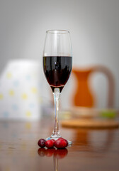 Glass of Red Wine with Cranberries on Wooden Table
