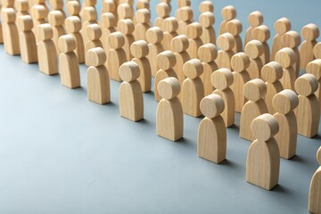 Obraz premium Wooden Figures in Formation: Rows of small, uniform wooden figures stand shoulder to shoulder, symbolizing unity, community, and collective action.