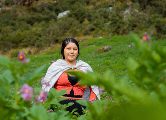 Foto de una feliz campesina caucásica parado en medio de sembrío de papas en Perú ,campesina con un tejido de manta artesanía peruana en la chacra,estilo de vida.Concepto de viaje.