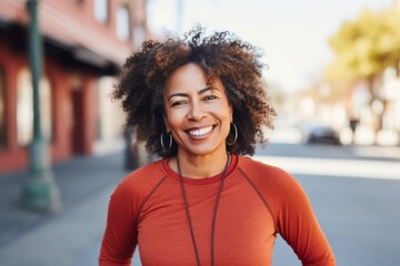 Portrait of a middle age body positive african american woman in sporty clothes smiling after running on the street