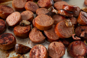 A view of a tray of sauteed turkey Polish kielbasa and mushrooms.