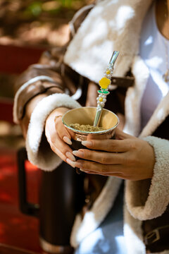 Guampa de mate con persona cargando agua
