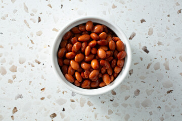 A top down view of a bowl of canned pinto beans.