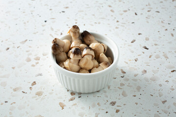A view of a bowl of canned straw mushrooms.
