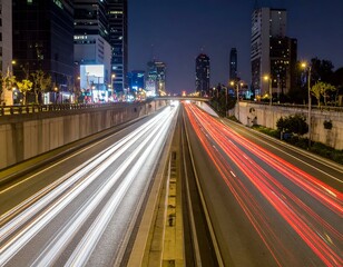 Obraz premium Night city highway traffic light trails. Urban cityscape at night with speeding cars creating vibrant light streaks.