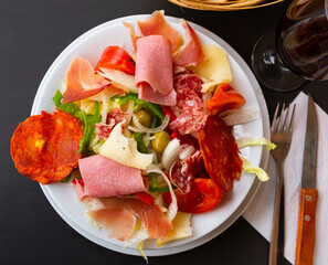 Plate of delicious Catalan salad of smoked sausage, ham, lettuce, bell pepper, tomatoes, cheese and chopped onions.....