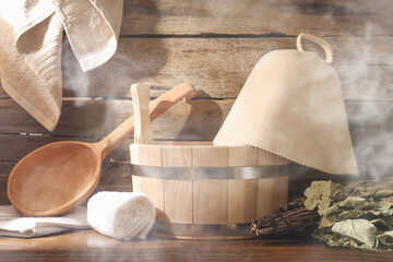 Sauna equipment. Bucket, ladle, felt wool hat, oak whisk and towels in steam