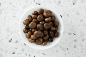 A top down view of a bowl of canned puffball mushrooms.